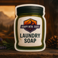 Soapy Mtn. Suds Command Laundry Soap featuring vanilla, lavender, smoky cedar, and rugged woodsy notes in a cozy cabin setting.