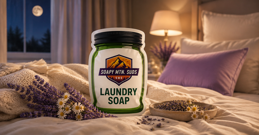 Luxury Pillow Talk Laundry Soap featuring lavender and chamomile beside soft cream-colored bedding in a cozy modern bedroom. Premium Soapy Mtn Suds laundry detergent with relaxing clean linen and spa-like nighttime aesthetic.