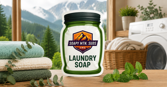 Soapy Mtn Suds Mountain Mist Laundry Soap, natural laundry detergent with crisp mountain air, eucalyptus, and spearmint scent in a bright laundry room.
